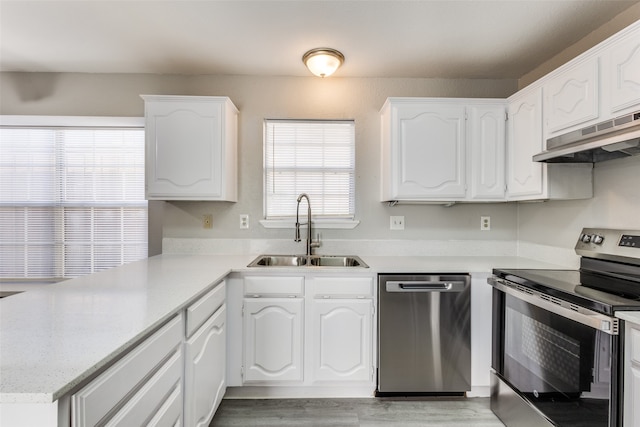 kitchen with white cabinets, sink, extractor fan, stainless steel appliances, and light hardwood / wood-style floors