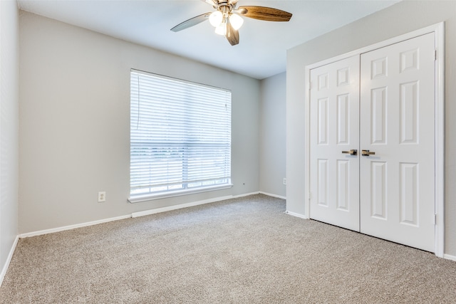 unfurnished bedroom with light carpet, ceiling fan, and a closet