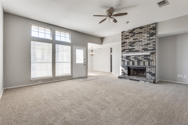 unfurnished living room featuring ceiling fan with notable chandelier, a fireplace, and carpet flooring