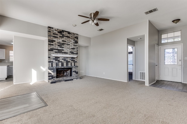 unfurnished living room with carpet floors, a fireplace, and ceiling fan