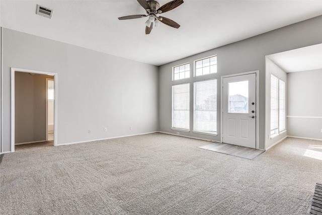 unfurnished living room with plenty of natural light, ceiling fan, and light carpet