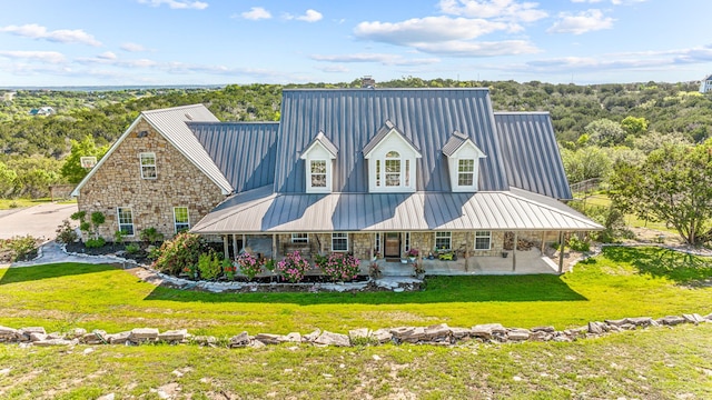 rear view of house featuring a yard and covered porch