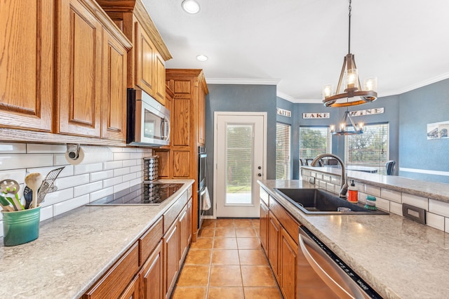 kitchen with hanging light fixtures, sink, appliances with stainless steel finishes, a notable chandelier, and crown molding