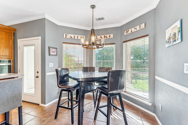 dining space with a healthy amount of sunlight, crown molding, a chandelier, and light tile patterned floors