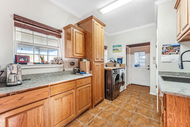 kitchen with light tile patterned flooring, ornamental molding, washer and dryer, and sink