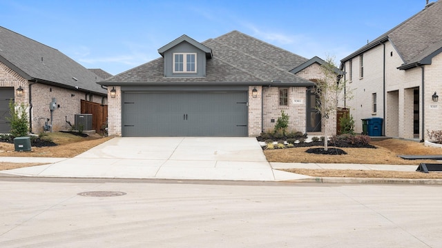 view of front of property with a garage and central AC unit