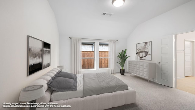 bedroom with light carpet and vaulted ceiling