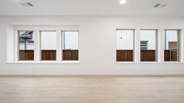 empty room with plenty of natural light and light wood-type flooring