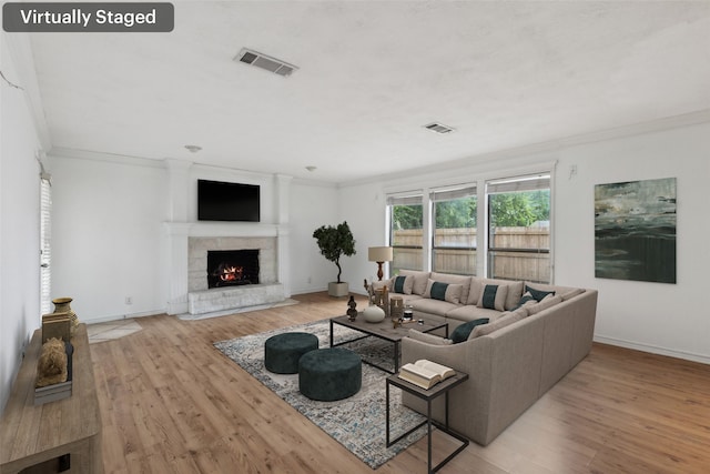 living room with light wood-type flooring and ornamental molding