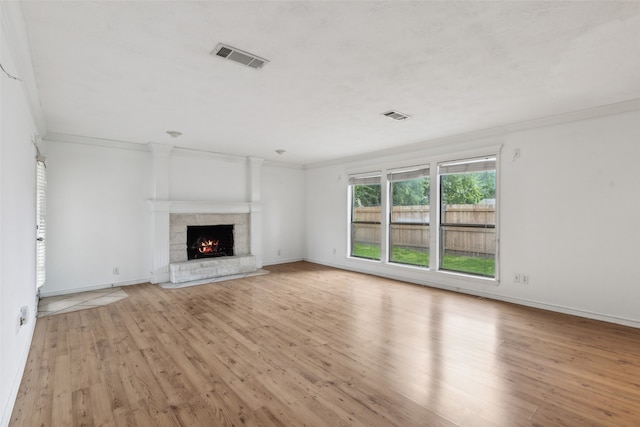 unfurnished living room featuring ornamental molding and light hardwood / wood-style flooring