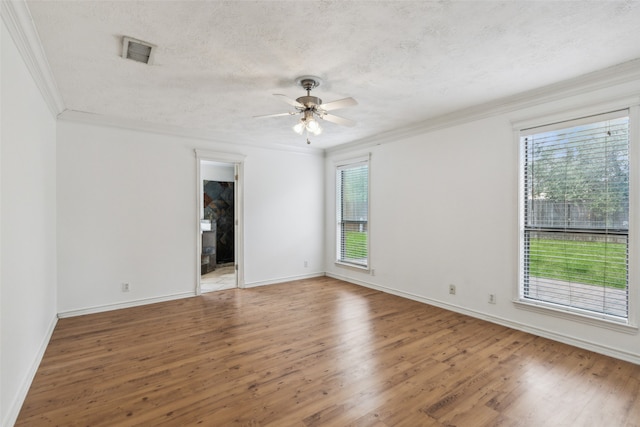 unfurnished room with ceiling fan, a textured ceiling, crown molding, and hardwood / wood-style floors