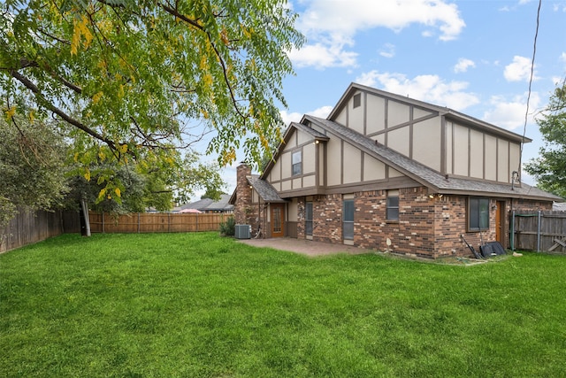 rear view of property with a lawn, a patio, and central air condition unit