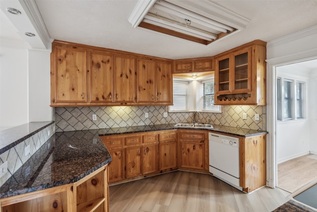 kitchen featuring light wood-type flooring, tasteful backsplash, crown molding, sink, and white dishwasher