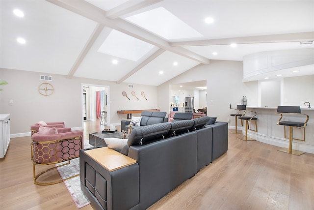 living room featuring light hardwood / wood-style flooring and lofted ceiling with skylight