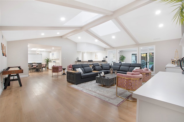 living room with vaulted ceiling with skylight and light wood-type flooring