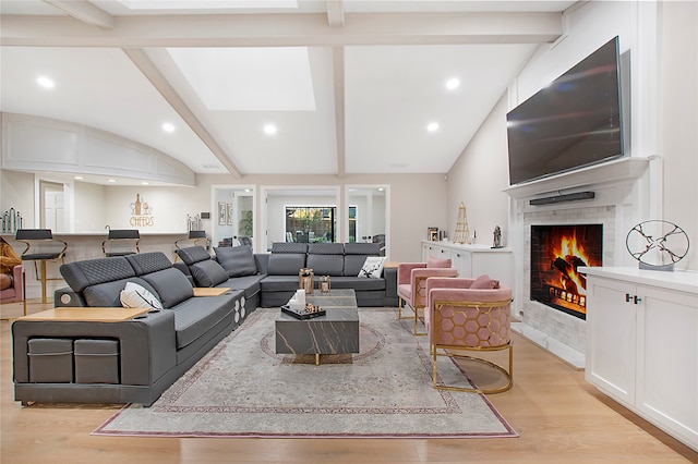 living room featuring lofted ceiling with beams and light wood-type flooring