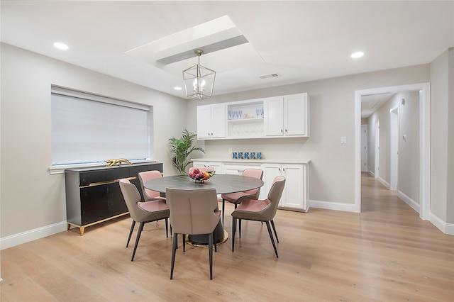 dining space featuring light hardwood / wood-style floors and a notable chandelier