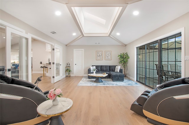 living room with light hardwood / wood-style floors and lofted ceiling with skylight