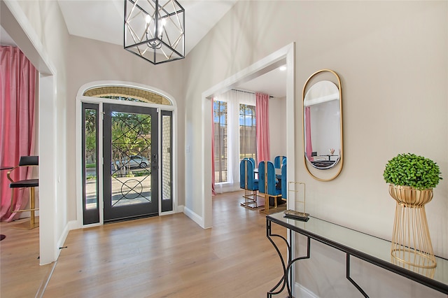 entryway featuring a high ceiling, a notable chandelier, and light hardwood / wood-style floors