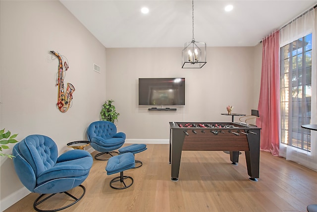 playroom with a chandelier, hardwood / wood-style floors, and a healthy amount of sunlight