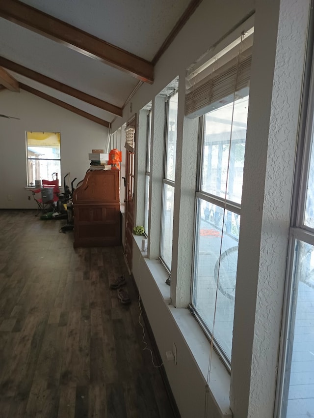 corridor with hardwood / wood-style floors and lofted ceiling with beams