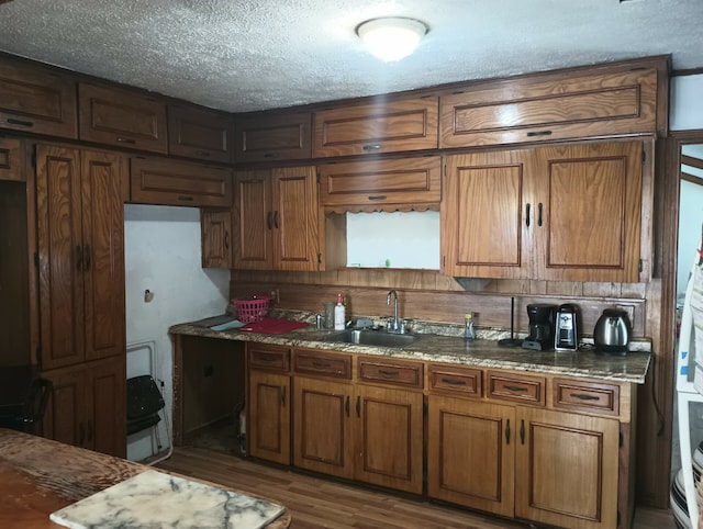 kitchen with dark hardwood / wood-style flooring, a textured ceiling, and sink