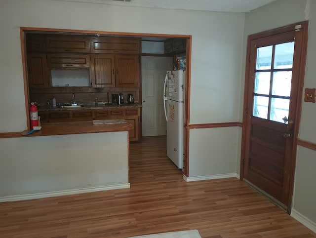 kitchen with sink, light hardwood / wood-style floors, white fridge, and a textured ceiling