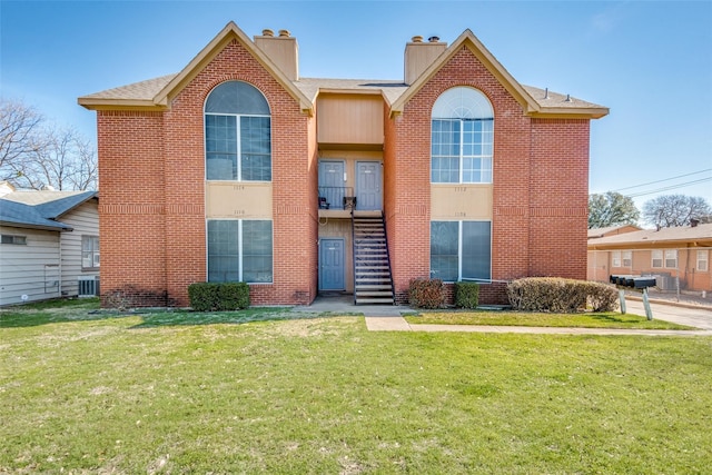 view of front facade featuring central air condition unit and a front lawn