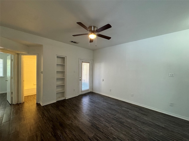 unfurnished bedroom featuring a spacious closet, dark hardwood / wood-style floors, and ceiling fan