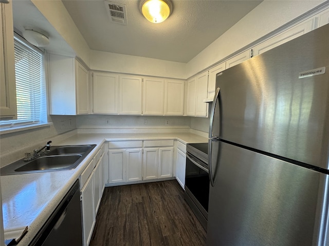 kitchen with appliances with stainless steel finishes, sink, dark hardwood / wood-style floors, and white cabinets