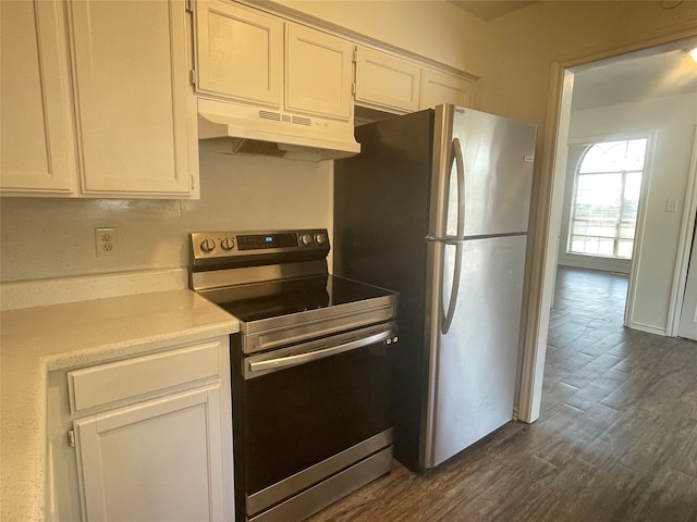 kitchen with dark wood-type flooring, appliances with stainless steel finishes, and white cabinetry