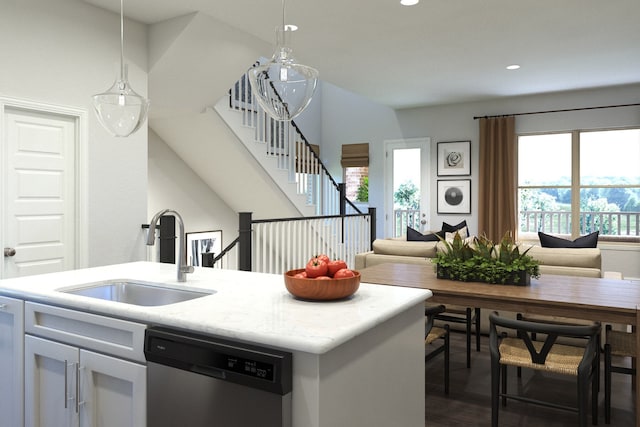 kitchen featuring sink, white cabinetry, hanging light fixtures, stainless steel dishwasher, and a kitchen island with sink