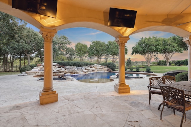 patio terrace at dusk with an in ground hot tub