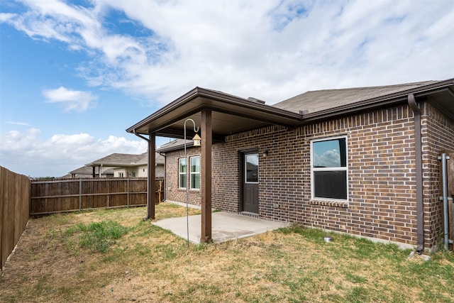 back of house with a patio area and a yard