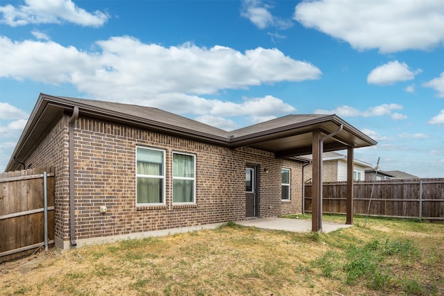 back of house featuring a patio and a lawn