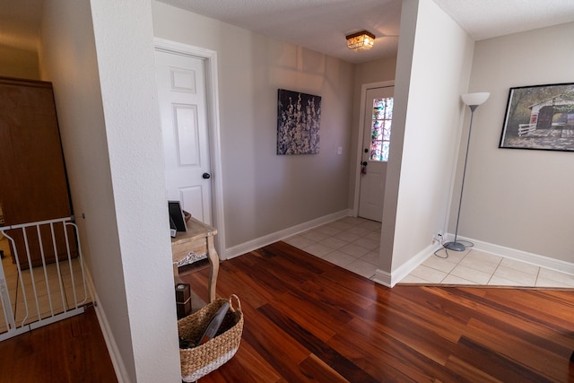 foyer entrance with light hardwood / wood-style flooring and a textured ceiling