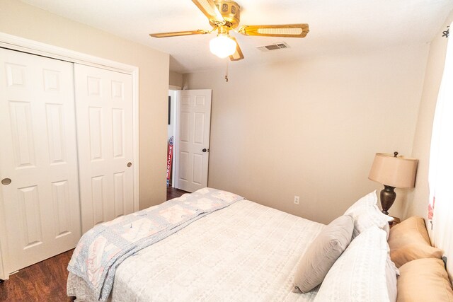 bedroom featuring ceiling fan, a closet, and dark hardwood / wood-style flooring