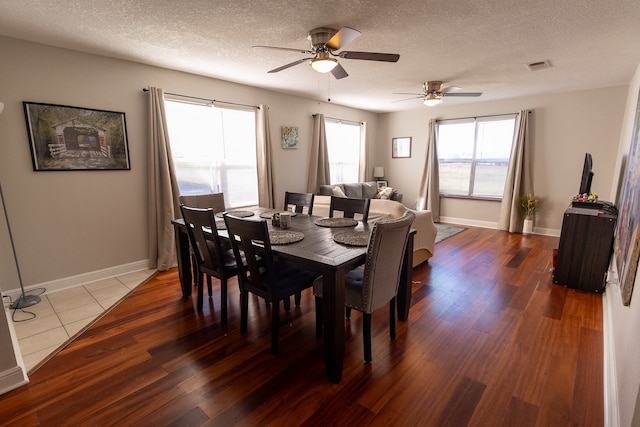 dining area featuring hardwood / wood-style flooring, ceiling fan, and a textured ceiling