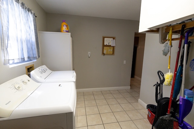 laundry area with separate washer and dryer and light tile patterned flooring