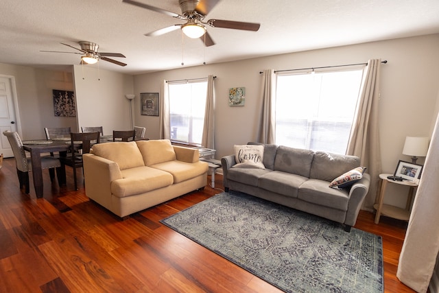 living room featuring ceiling fan, a textured ceiling, plenty of natural light, and dark hardwood / wood-style flooring