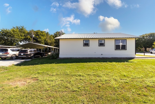 view of side of home featuring a carport and a lawn