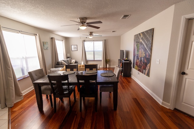 dining area with dark wood-type flooring, a textured ceiling, and ceiling fan