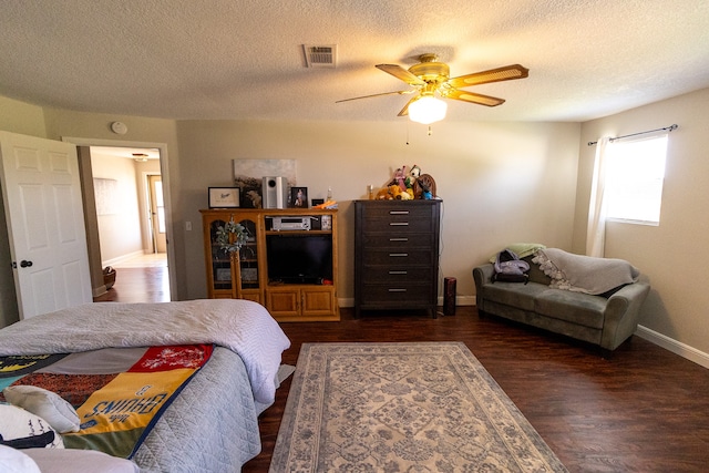 bedroom with a textured ceiling, ceiling fan, and dark hardwood / wood-style flooring