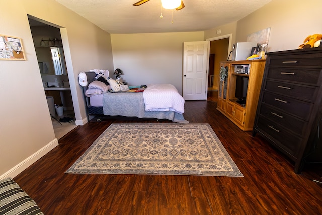 bedroom featuring a textured ceiling, ensuite bathroom, dark hardwood / wood-style flooring, and ceiling fan