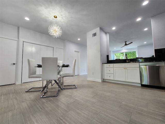 dining space featuring ceiling fan with notable chandelier and sink