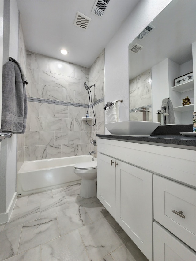 full bathroom featuring tiled shower / bath, vanity, and toilet