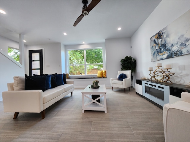 living room featuring ceiling fan and a wealth of natural light