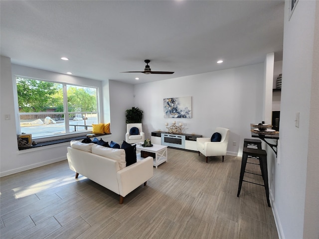 living room with wood-type flooring and ceiling fan