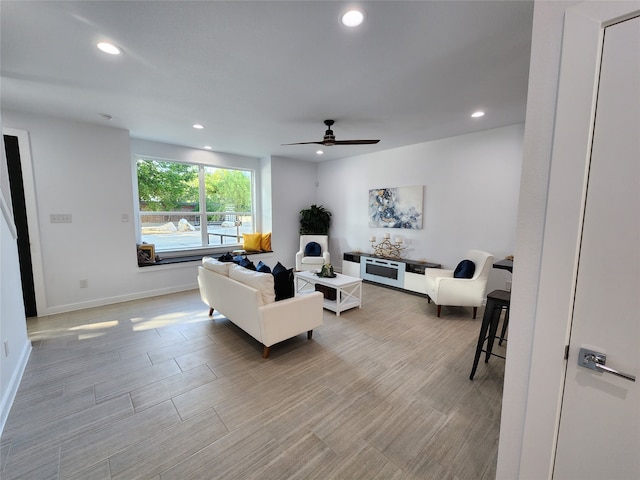 living room featuring light wood-type flooring and ceiling fan