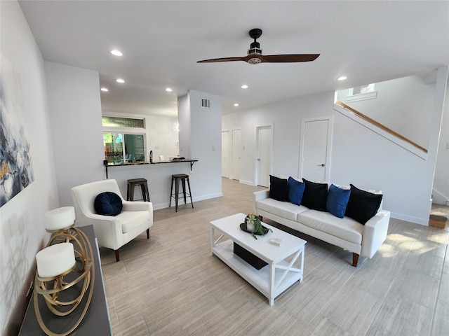 living room featuring ceiling fan and sink